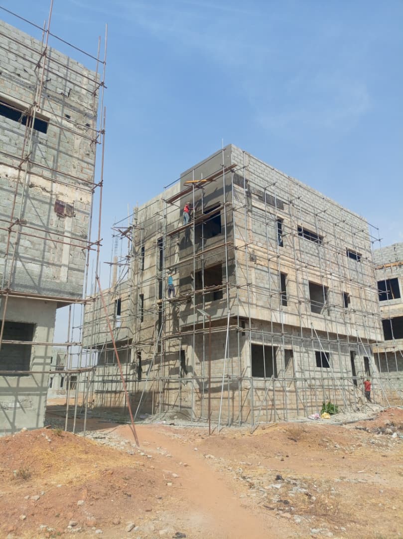 Walls rising rapidly as bricklayers construct the exterior blocks.